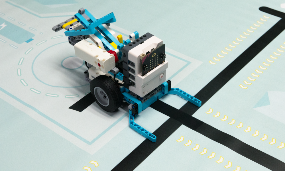 DIY robot kit with micro:bit controlled sports robot following a black line on a competition mat, designed for STEM education, coding practice, and robotics challenges