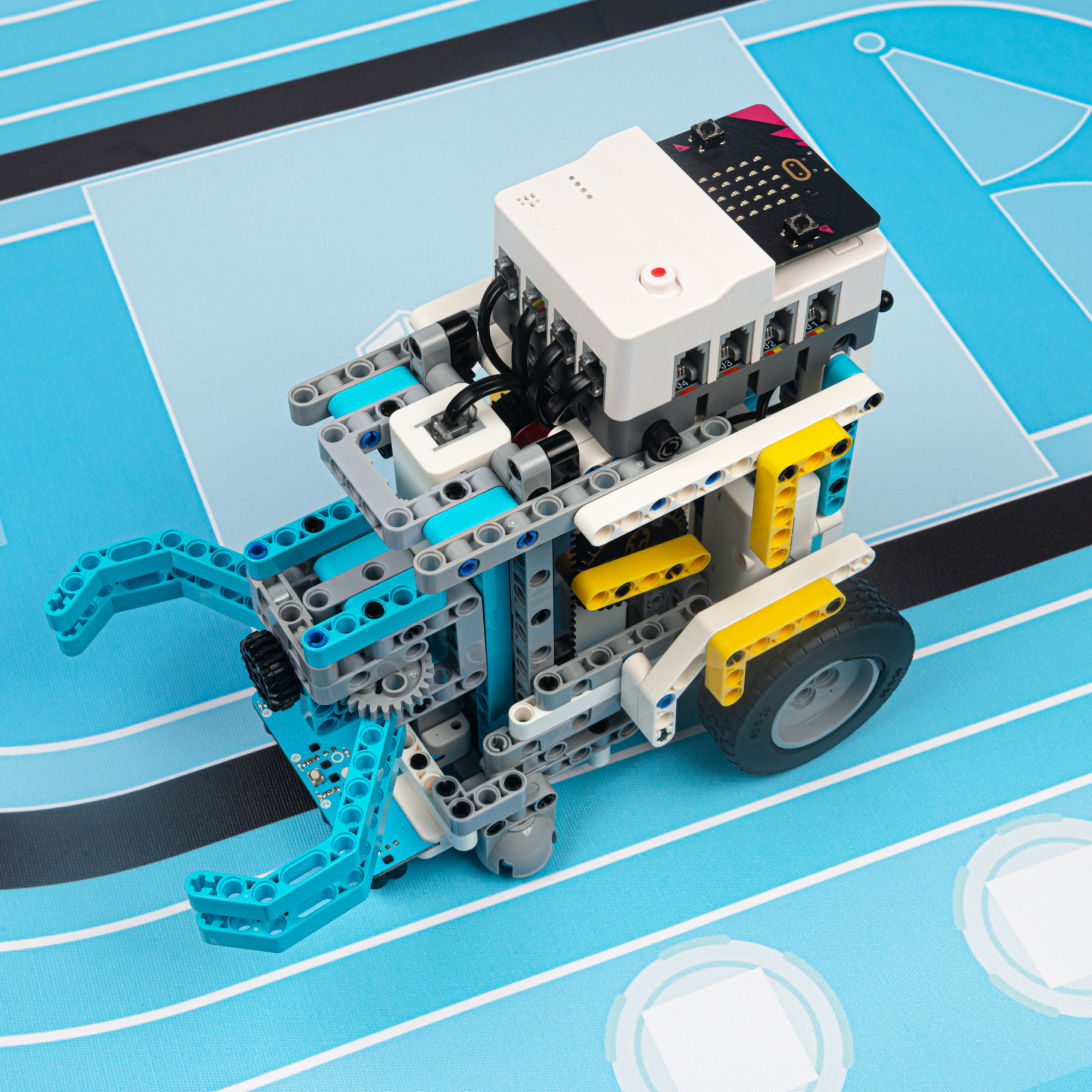 A robot built using the Nezha Pro Sports Kit, featuring a gripper arm mechanism. The robot is shown on a blue sports-themed mat, with visible sensors and motors for dynamic interaction. This DIY robot kit is ideal for building and programming robots for various activities and challenges