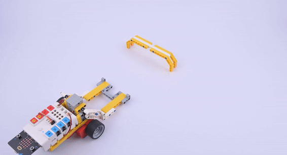Nezha coding robotic kit robot car built with LEGO compatible parts driving through a yellow block gate